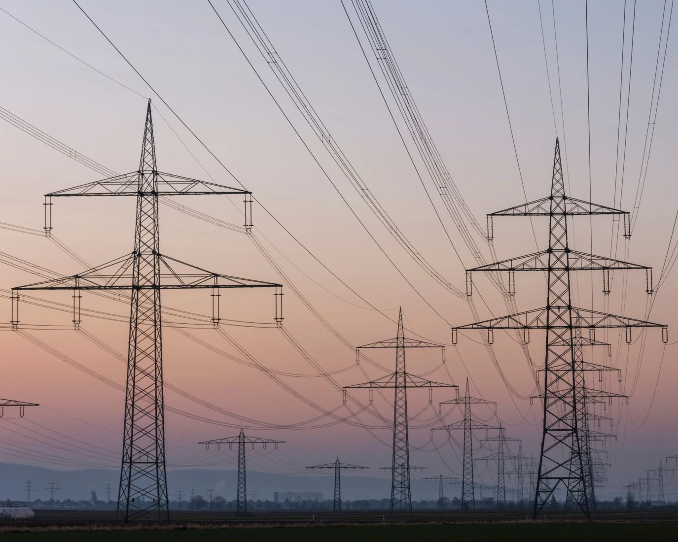 Electricity transmission pylons and power lines at dusk