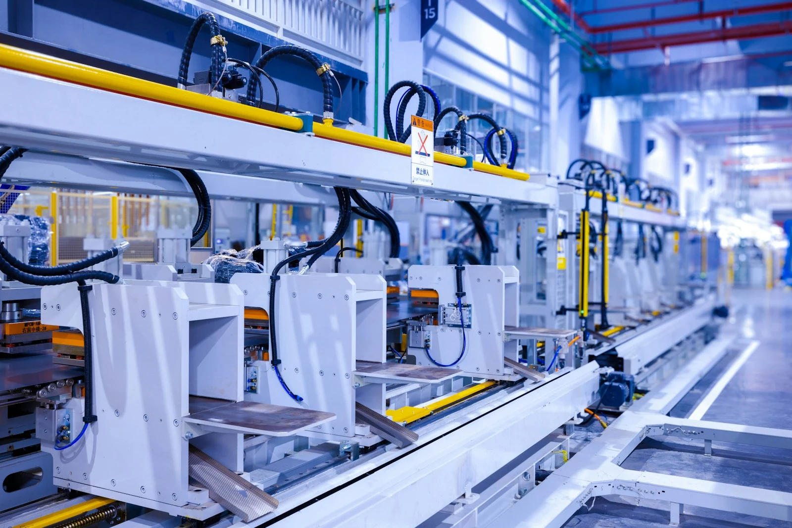 Modern factory production line with white machinery and yellow safety rails
